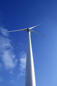 Electric wind mill viewed from the floor over blue sky, ecological windmill