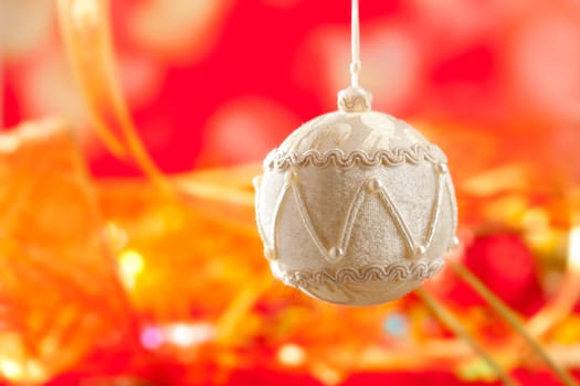Christmas card of white velvet bauble and red blur background