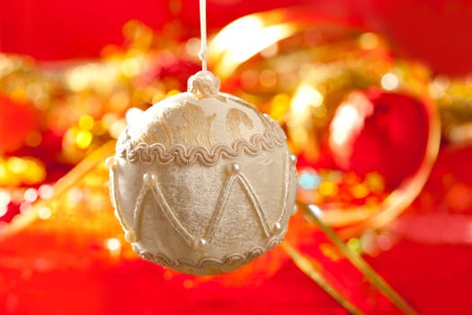 Christmas card of white velvet bauble and red blur background