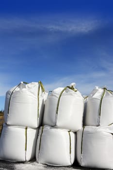 salt white sacks rows stacked to prevent ice  roads asphalt