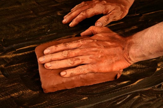 artist man hands working red clay to create handcraft art