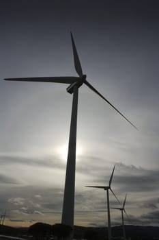aerogenerator electric windmill on sunset cloudy sky