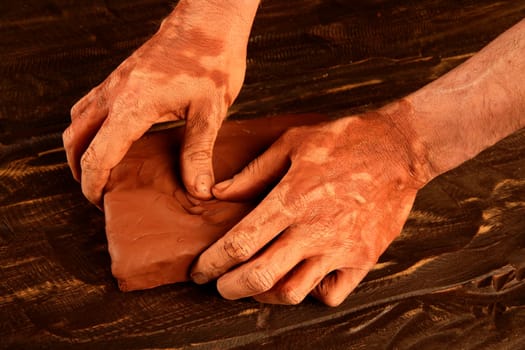 artist man hands working red clay to create handcraft art