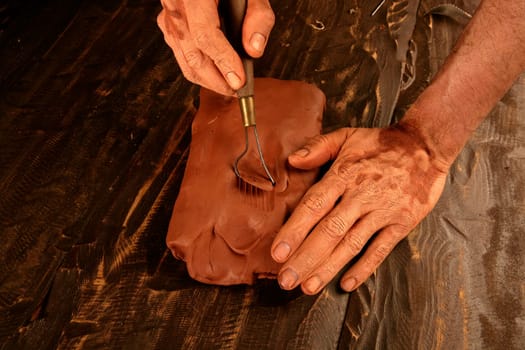 artist man hands working red clay to create handcraft art