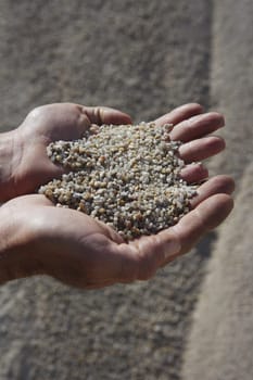 gravel sand in man hands in quarry showing camera