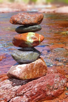 Rolling stones stacked red rodeno limestone in river Pyrenees