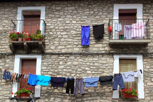 Clothes line hanging from stone wall houses in Spain