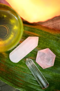 Aromatherapy, stones, oil, relaxing spa therapy over green leaf and orange light
