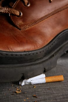 Boot treading cigarette tobacco addiction concept metaphor