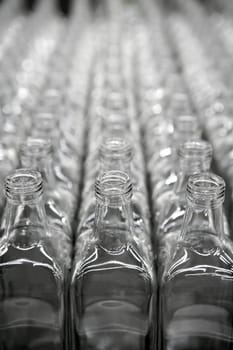 Glass square transparent bottles, factory lines and rows