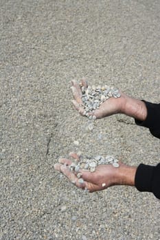 gravel rolling stones falling man hands in quarry background