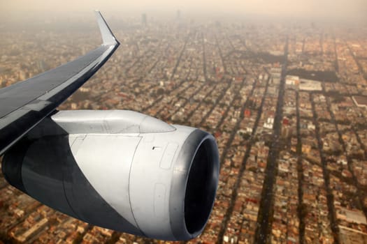 aircraft wing with turbine flying over Mexico DF city