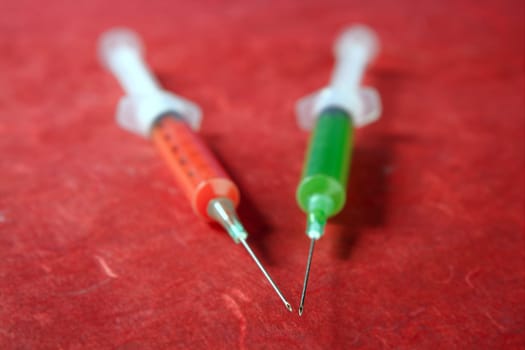 health still life red and green syringes over red background