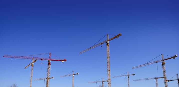 Construction cranes view over blue sky in Spain