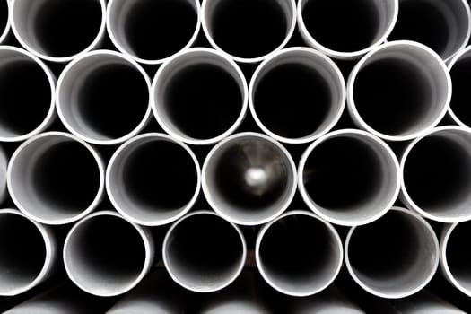 gray PVC tubes plastic pipes stacked in rows pattern