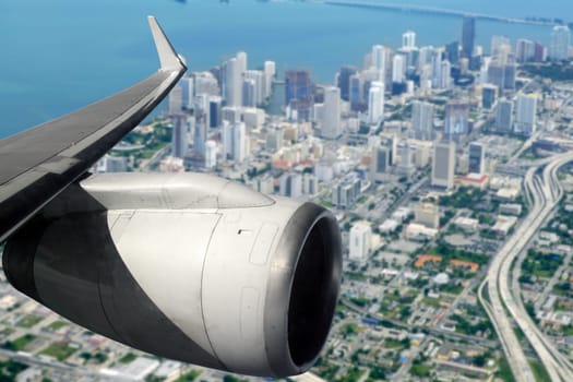 airplane wing aircraft turbine flying on Miami downtown