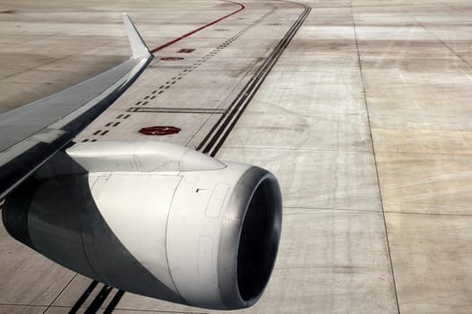 airplane wing with turbine landing on runway road