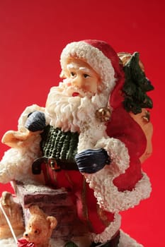 Santa Claus figurine over red background, studio shot