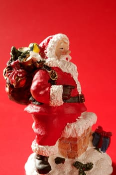 Santa Claus figurine over red background, studio shot