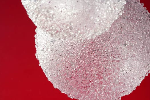 Balls over red background, transparent spheres in white plastic over red background