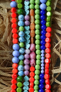Color stones jewelry necklaces over natural straw and tulle background