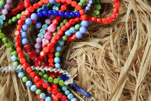 Color stones jewelry necklaces over natural straw and tulle background