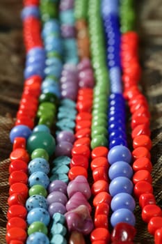 Color stones jewelry necklaces over natural straw and tulle background