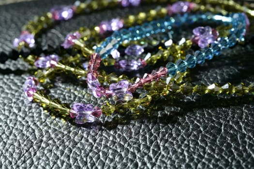 necklaces over black shiny black leather pattern background