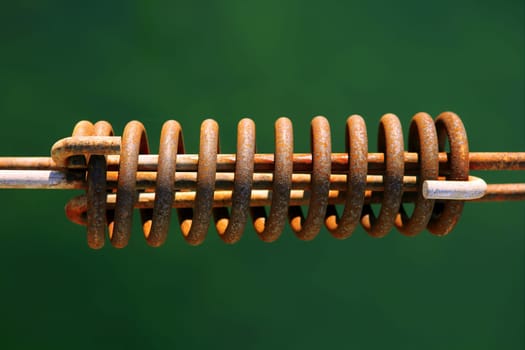 Aged mooring rusted spring over green water background