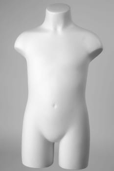 Mannequin of a child in white over gray background