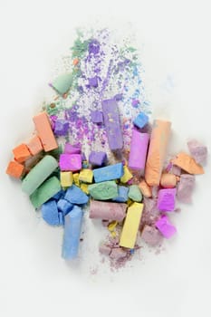 Colorful chalk broken colors mess over white background