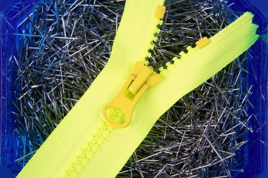 Dressmaker pins background with yellow zip over