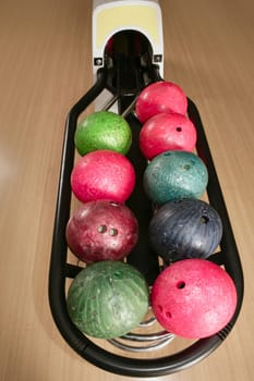 Bowling balls perspective in game center wooden floor