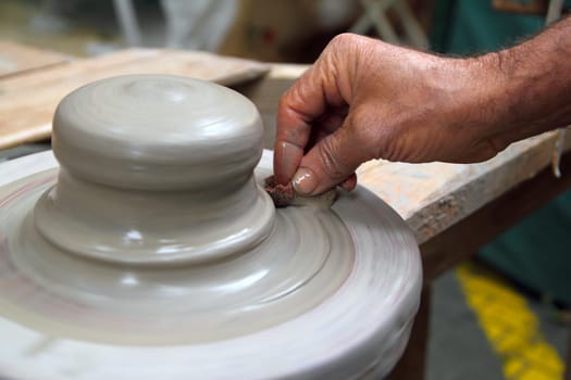 man potter hands working on pottery clay wheel stoneware sponge