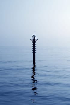 back light navigation beacon in Mediterranean blue sea water reflection