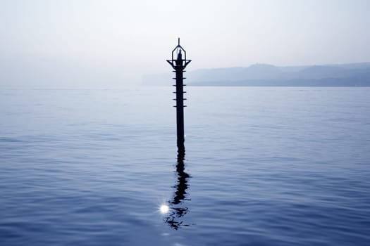 back light navigation beacon in Mediterranean blue sea water reflection