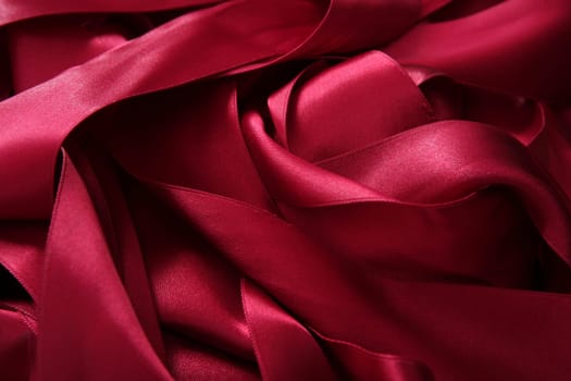 Red satin ribbons in a messy mess texture background