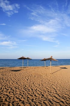 Blue beach in mediterranean sea with summer vacation umbrellas