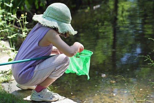 details of a girl fishing frogs with a net