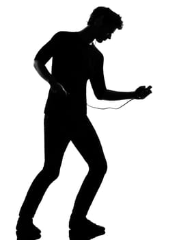 young man listening music audio player silhouette in studio isolated on white background