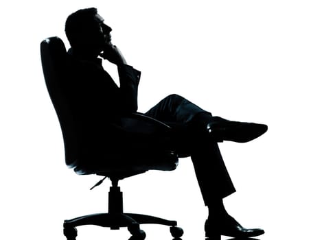 one caucasian business man relaxing thinking sitting in armchair silhouette Full length in studio isolated on white background