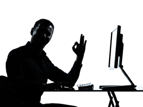 one caucasian business man computer computing ok gesture silhouette in studio isolated on white background