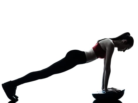 one caucasian woman exercising bosu balance ball trainer in silhouette studio isolated isolated on white background