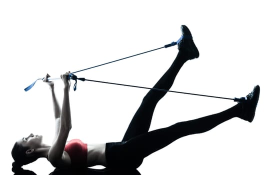 one caucasian woman exercising elastic gymstick in silhouette studio isolated on white background