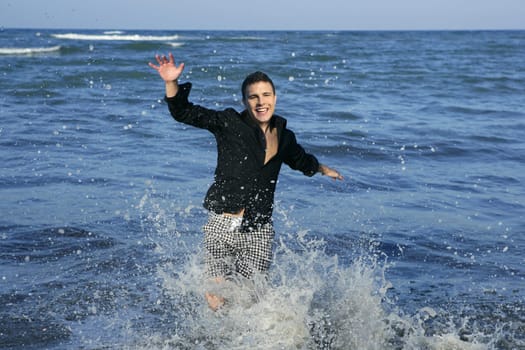 Man running happy on the blue summer beach, sunny summer
