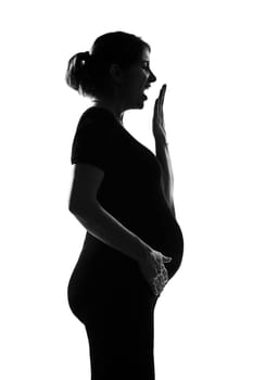 beautiful caucasian pregnant woman yawning tired in silhouette on studio isolated white background