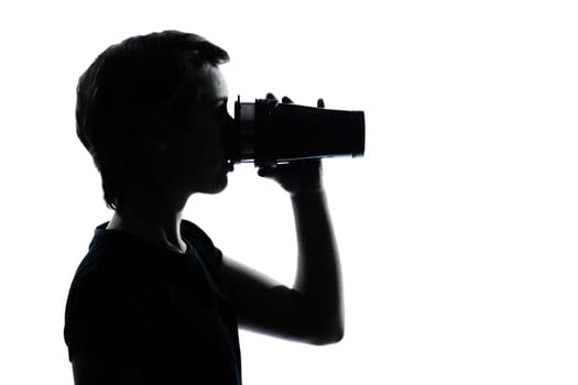 one caucasian young teenager drinking at thermos travel mug  silhouette boy or girl portrait in studio cut out isolated on white background