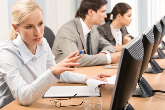 Successful professional pointing at computer monitor during seminar