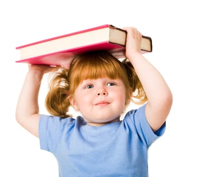 Portrait of young smiling child holding textbook over her head