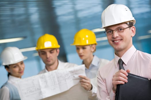 Portrait of confident foreman in helmet and eyeglasses looking at camera